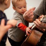 baby music class and teacher with guitar